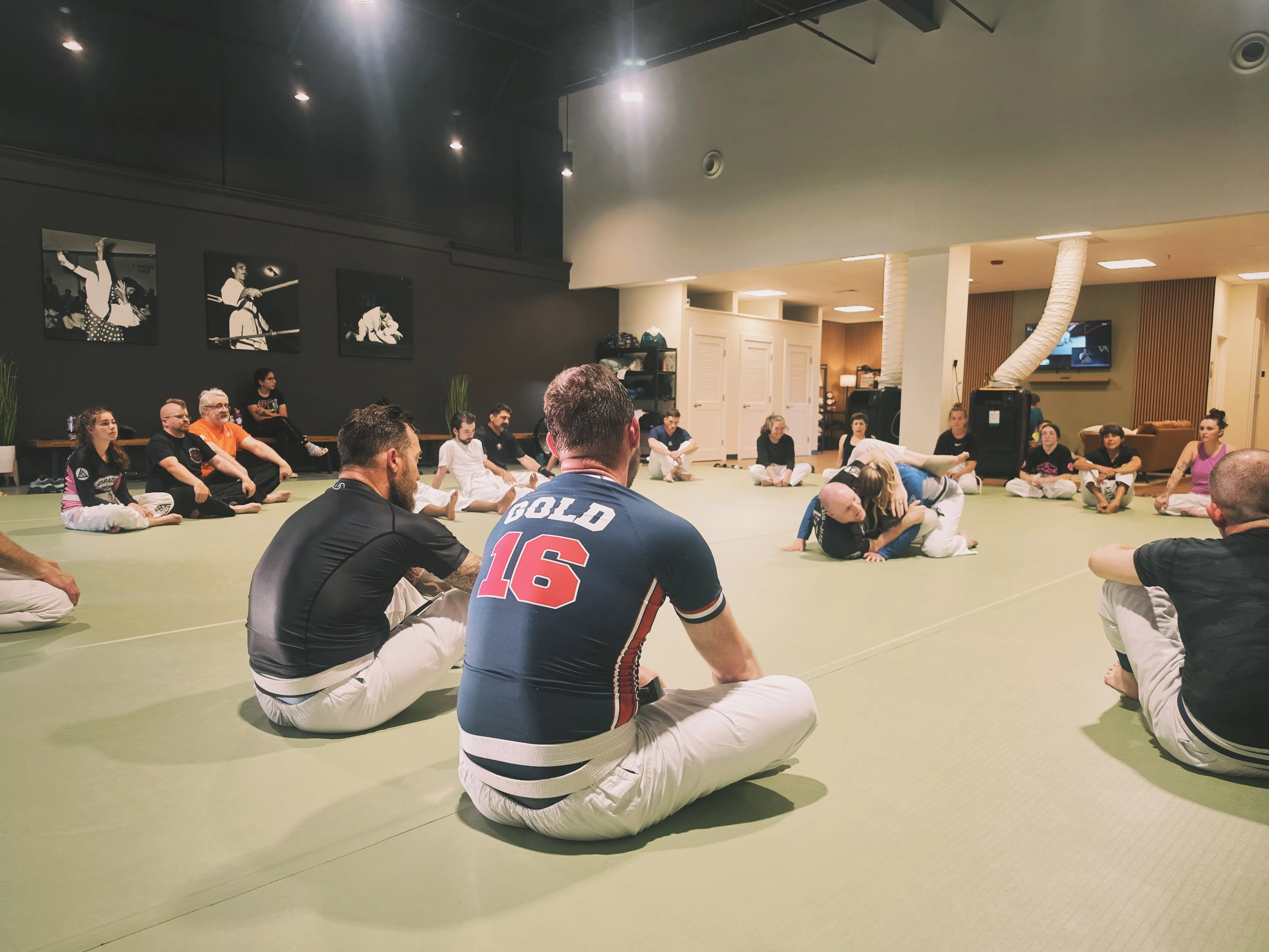 A student sitting in on class, part of a circle of students listening during a training session.