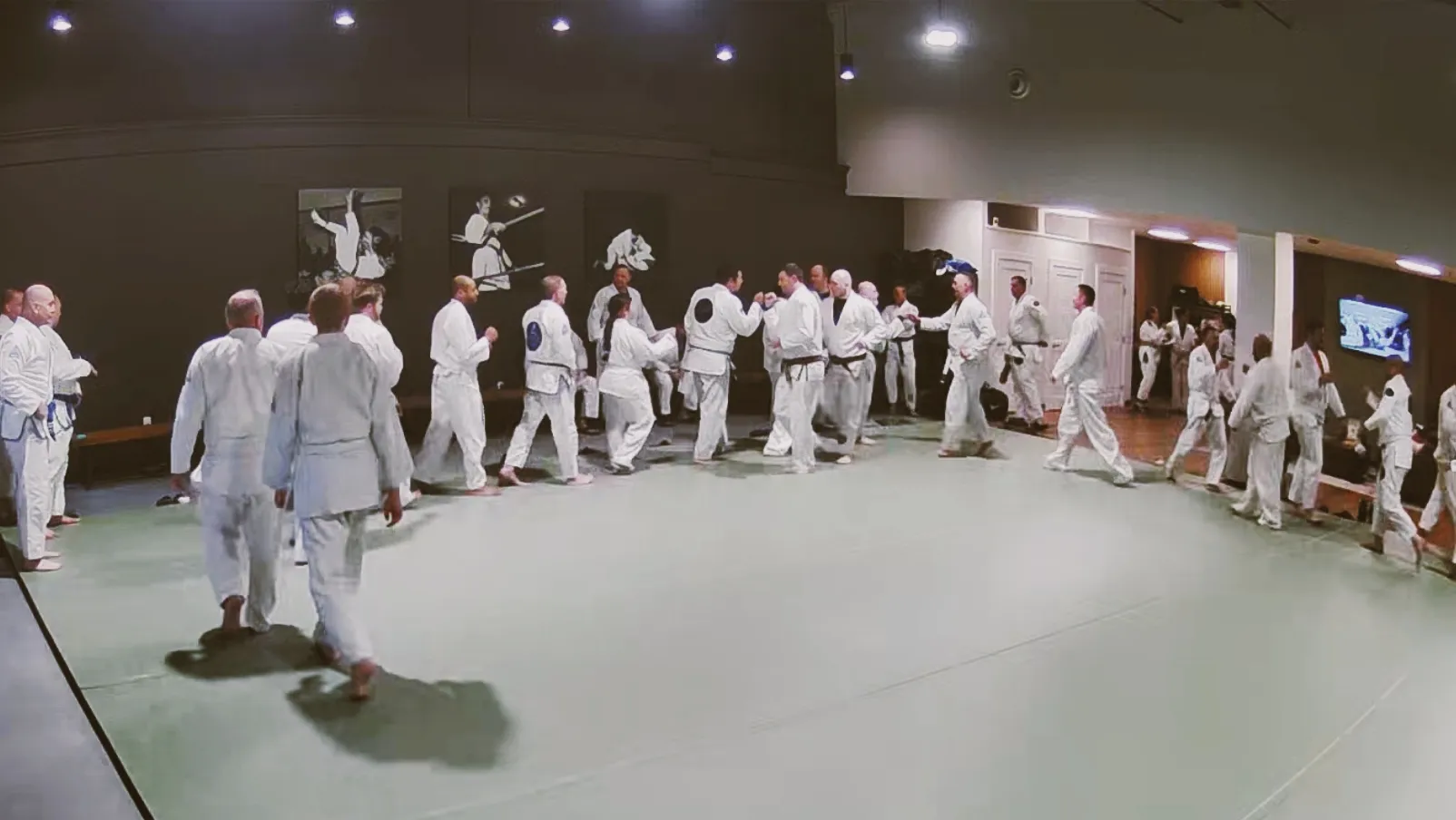An instructor demonstrating a control position with a student on the mat.